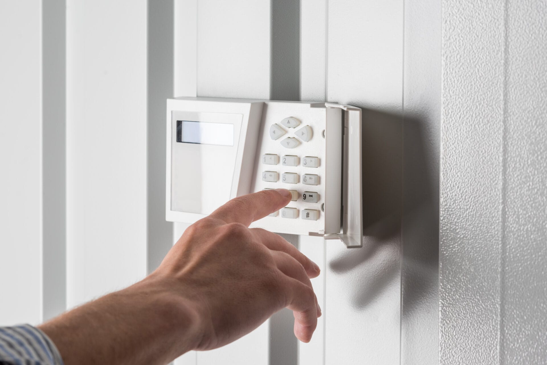 Person entering a code on a home alarm keypad