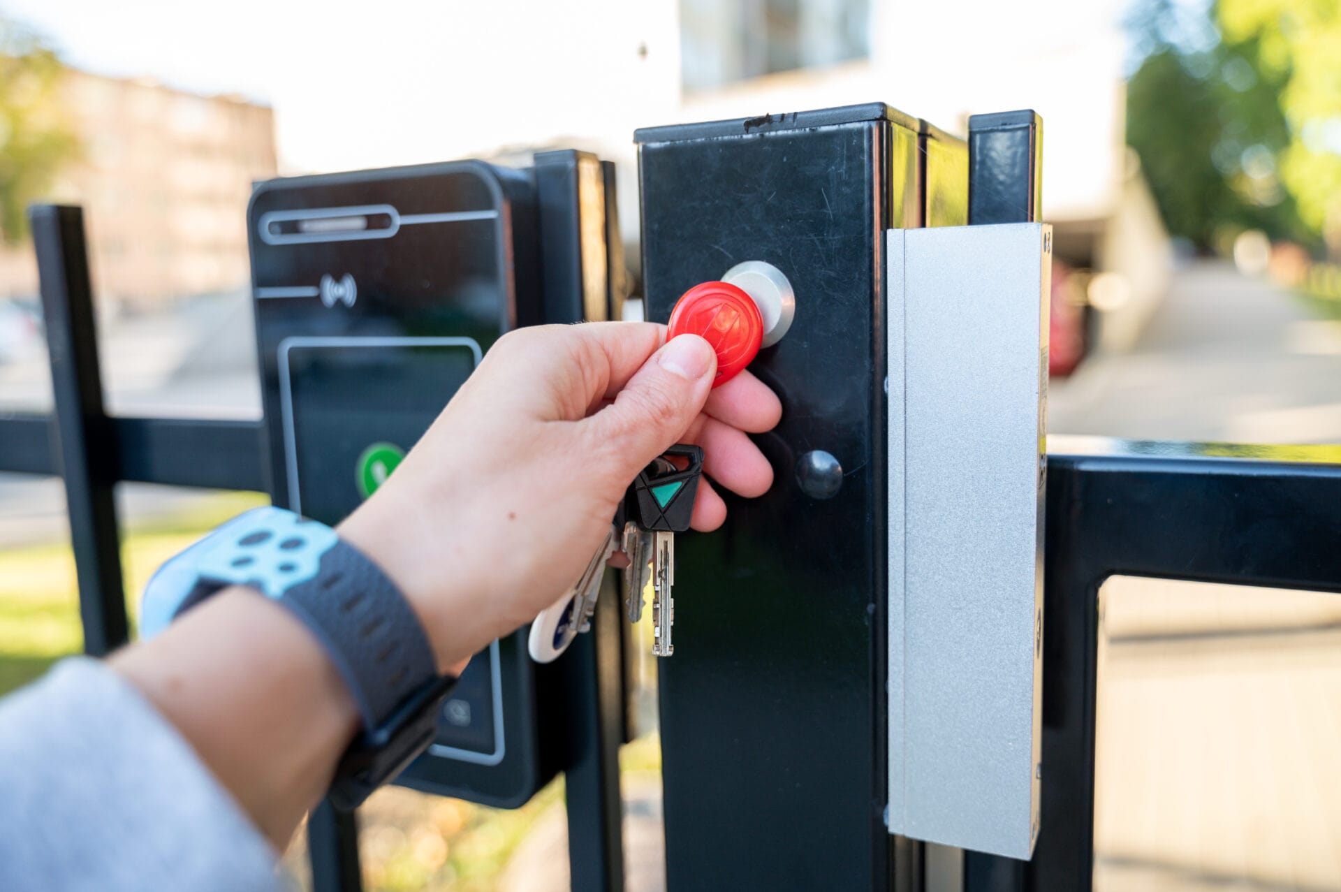 Hand holding house keys opening a door secured with an access control system